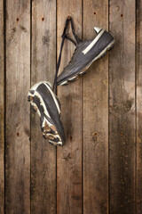 Soccer shoes hanging on a weathered wooden wall