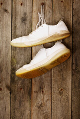 Sport shoes hanging on a weathered wooden wall