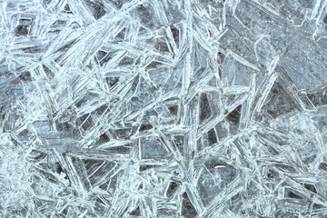 A detailed view of intricate ice crystals formed on a surface, showcasing their delicate structures.