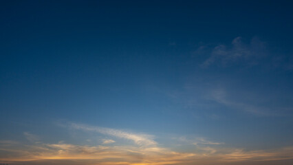 blue sky with soft wispy clouds at sunrise