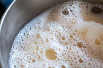 A stunning close-up of milk foam beautifully filling a silver pan, creating an intricate surface pattern that showcases the richness and appeal of quality milk.