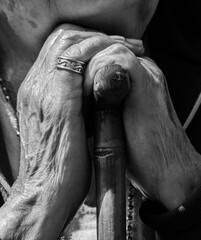 Manos envejecidas de abuela sosteniendo un bastón, imagen en blanco y negro