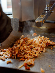 Making Shawarma: Cutting grilled meat