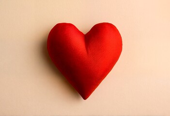 Fototapeta premium A red heart-shaped pillow with a ribbed texture.