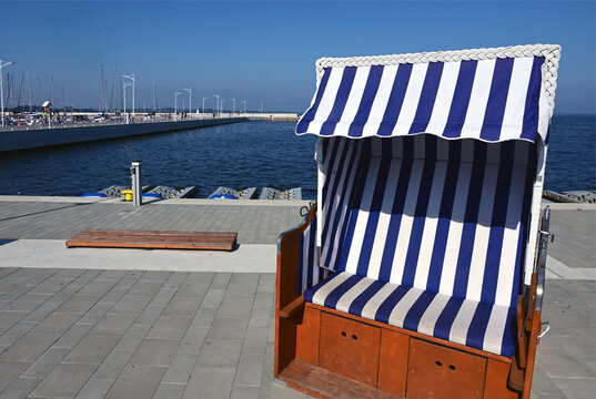 Puck, Kashubia, Pomeranian Voivodeship, Pomerania, Poland, Europe : coast of Bay of Puck, pedestrian molo and roofed wicker beach chair, at left marina, Zatoka Pucka, Baltic Sea