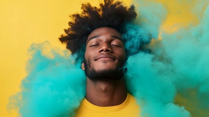 A young man with wavy hair smiles serenely while surrounded by swirling clouds of blue and green smoke against a bright pastel yellow background, creating a modern vibe