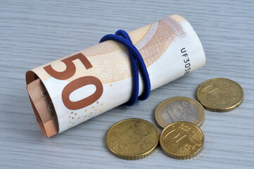 Concept d'argent de poche avec des billets de cinquante euros enroulés autour d'un élastique et...