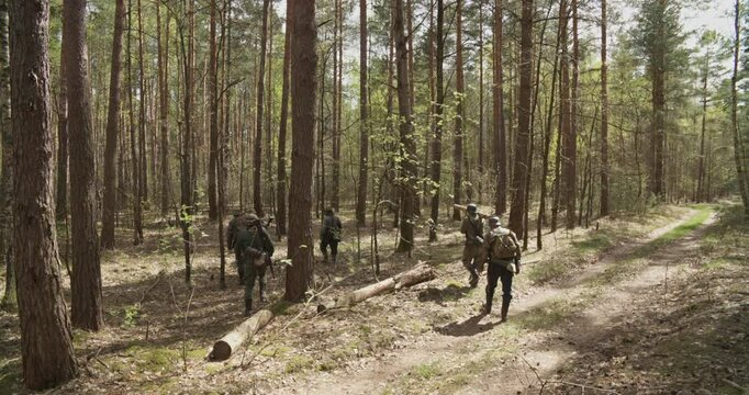 Reenactors Dressed As German Infantry Soldiers Marching By Forest Autumn Season. Group Of Soldiers With Carabines Mauser 98k, Panzerschreck Combing Forest. Reenactment Game. Wermacht Military Uniform