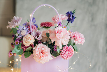 Beautiful pink flowers composition in the box close-up view. Festive decoration and background