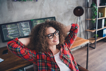 Confident Female Programmer Relaxing in a Modern Home Office Workspace, Coding on a Computer in a...
