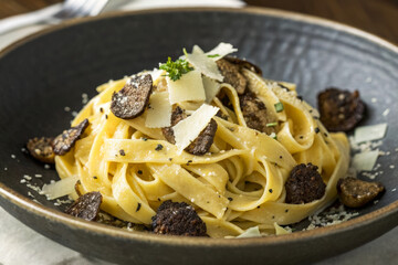 Creamy Fettuccine Pasta with Mushroom and Parmesan Cheese in Elegant Black Bowl