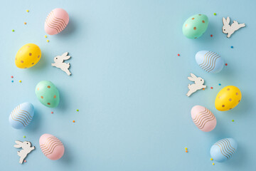 Decorative Easter setup featuring pastel-colored eggs and bunny figures on a light blue surface
