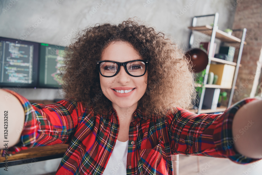 Poster cheerful young female programmer taking a selfie in a modern workspace, showcasing coding skills and