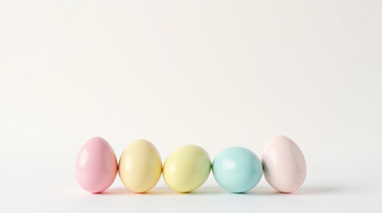 Fototapeta premium Easter eggs in pastel colors, yellow, pink, blue and peach, in a minimalist composition on a white background