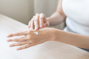 Healthy skin care, beauty asian young woman hand applying moisturizer, putting cream treatment on back hand after shower bath at home, makeup routine in the morning, treatment skin care body concept.