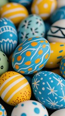Pile of painted Easter eggs, colored eggs with white, yellow and orange festive patterns, dyed decorations for spring holiday celebrations.