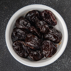 Dried prunes smoked drained plum gourmet food background on the table rustic food top view copy space keto and paleo diet vegetarian and vegan food