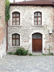 Vintage Stone Facade with Arched Windows and Wooden Door Composition