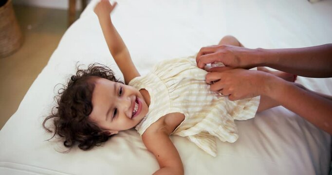 Laughing, mother and tickle baby on bed for bonding, playing games and child development in home. Above, woman or happy kid in bedroom with fun activity, funny or security with support, trust or care