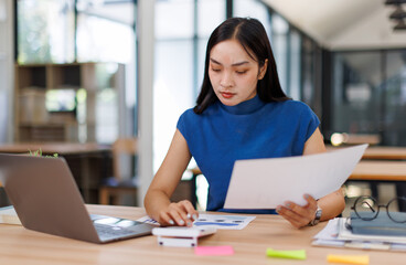 Fototapeta premium Business asian woman working in the office with working notepad, tablet and laptop documents tax, report, accounting, statistics, and analytical research concept 