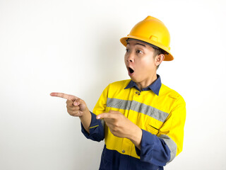 Shocked Young Asian worker shocked and shouting wow while pointing with his hand isolated on white...