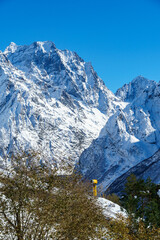 Picturesque landscape in Dombay with amazing snow-capped peaks and majestic blue slopes of North Caucasus Mountains. Mountain ski resort in Karachay-Cherkessia, Russia