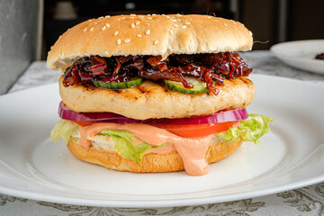 A delicious burger features a juicy patty, fresh vegetables, and savory toppings on a sesame bun