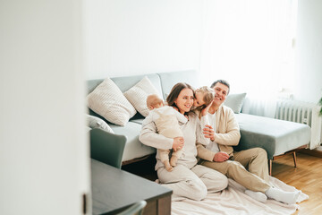 Beautiful happy young family with small children resting at home.