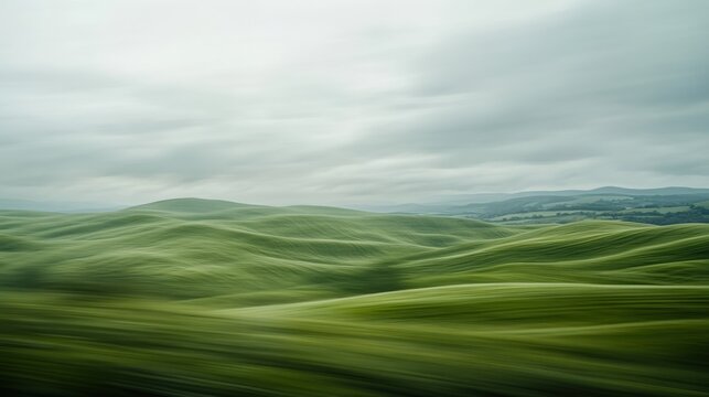 Blurred motion landscape of rolling green hills under a cloudy sky.