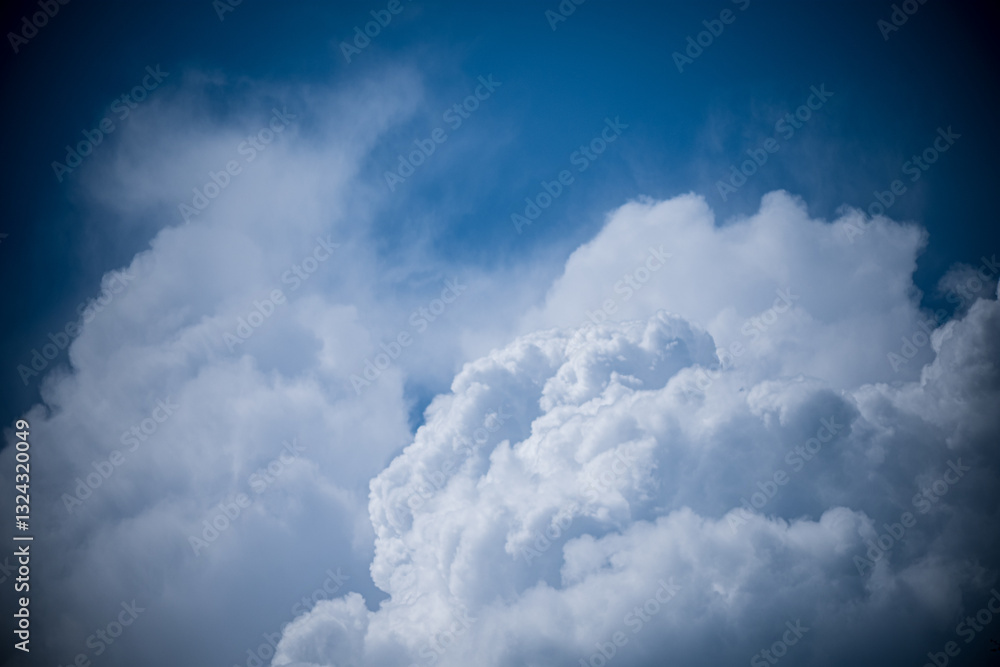 Wall mural fluffy white clouds float serenely in a bright azure sky, casting soft shadows below
