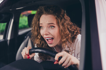 Photo of afraid scared woman wear white shirt driving auto first time outdoors urban city street