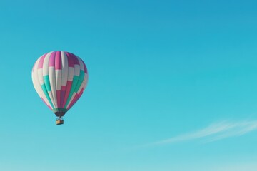 Fototapeta premium colorful hot air balloon floats serenely against clear blue sky with expansive copy space above capturing tranquility