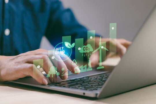 Environmental and sustainability concept, businessman working with computer analyzing data with environmental impact, renewable energy, air pollution reduction targets and carbon emissions with graph - Powered by Adobe