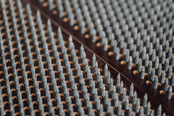 Obraz premium sadhu boards close-up view, wooden boards with metal nails, yoga equipment for standing with legs on them, relaxation concept, metal nails pattern, selective focus