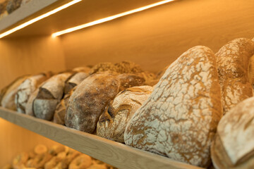 Close up shot of freshly baked bread loafs on a wooden shelf