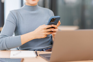 business asian woman in formal attire in her office happy and cheerful while using smartphones and working.using apps on cell phones, reading news, fast connection