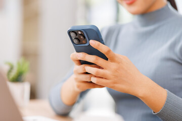 business asian woman in formal attire in her office happy and cheerful while using smartphones and...