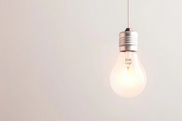single incandescent light bulb suspended against pale background softly glowing in center of image symbolic of inspiration