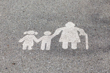 Top view of a modern white pedestrian sign on a concrete road.
