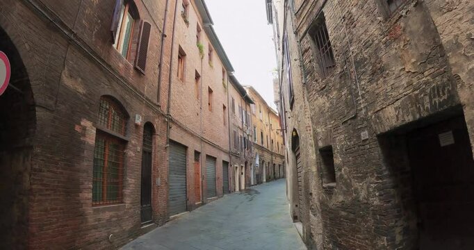 Pov walk in historic narrow cobblestone street in the heart of Siena, Tuscany, Italy