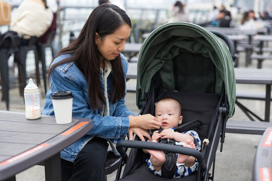 Mother taking care baby in stroller outdoor