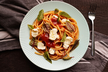 Salad caprese or pasta spaghetti with basil and mozzarella, top view
