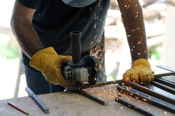 
Grinder throwing sparks as worker cuts metal