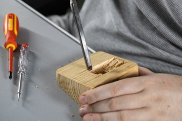 hand using a sharp chisel to carve a groove in a wooden block, detailed woodworking process in a...