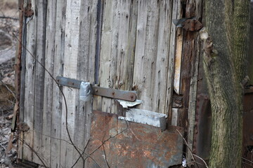 Old outhouse with rusty door, suitable for rustic or rural themed scenes.