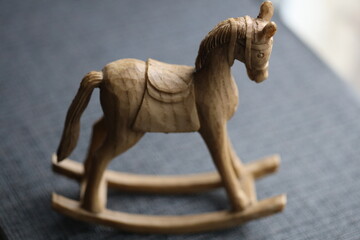 A classic wooden rocking horse sits on a bright blue surface, ready for imagination and play.