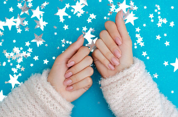 Women's nude manicure on a blue background. Beauty and health. Beauty procedure. Women's hands.