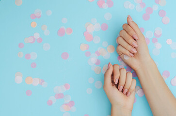Women's nude manicure on a blue background. Beauty and health. Beauty procedure. Women's hands.