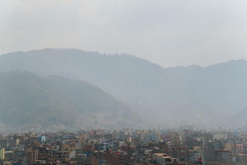 Cityscape of Kathmandu, the capital of Nepal, with mountains in the background and smog