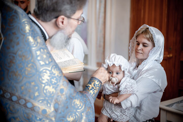 anointing of a small child in an Orthodox Christian church or temple during the sacrament of...